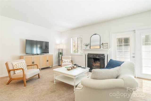 living room with a high end fireplace, light colored carpet, and baseboards