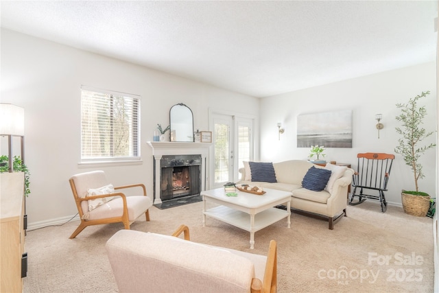 living area featuring baseboards, french doors, a premium fireplace, and light colored carpet