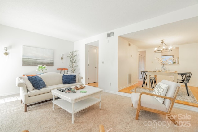 living area featuring light colored carpet, visible vents, and baseboards