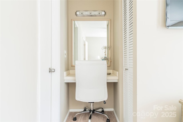 home office featuring built in desk and baseboards