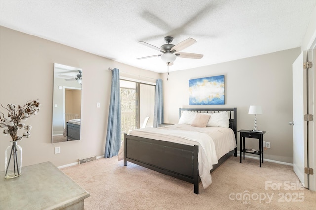 bedroom with a textured ceiling, light colored carpet, a ceiling fan, baseboards, and visible vents