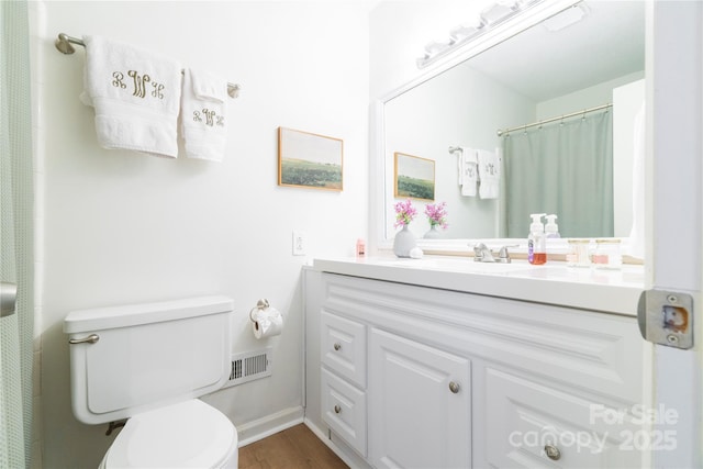 full bath featuring visible vents, a shower with shower curtain, toilet, wood finished floors, and vanity