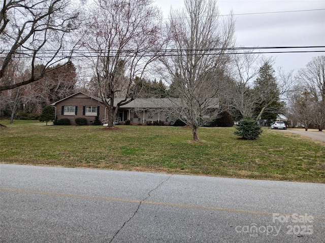 view of front of house featuring brick siding and a front lawn