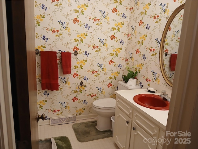 bathroom with visible vents, toilet, vanity, and wallpapered walls