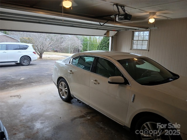 garage with a garage door opener and wood walls