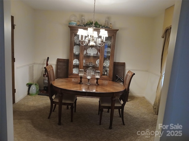 dining room with carpet floors and a chandelier