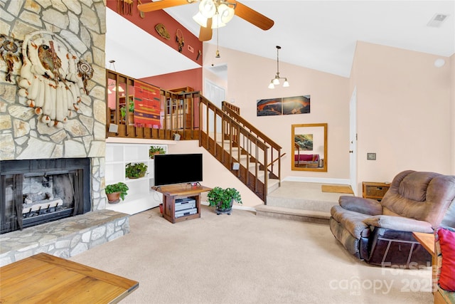 carpeted living area featuring high vaulted ceiling, a fireplace, visible vents, a ceiling fan, and stairs