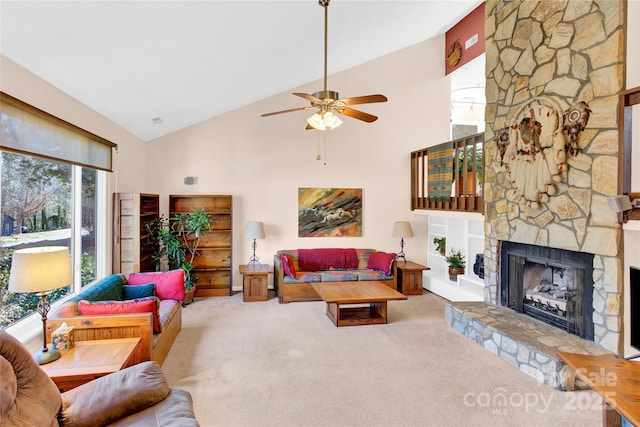 living area featuring carpet floors, high vaulted ceiling, a stone fireplace, and ceiling fan