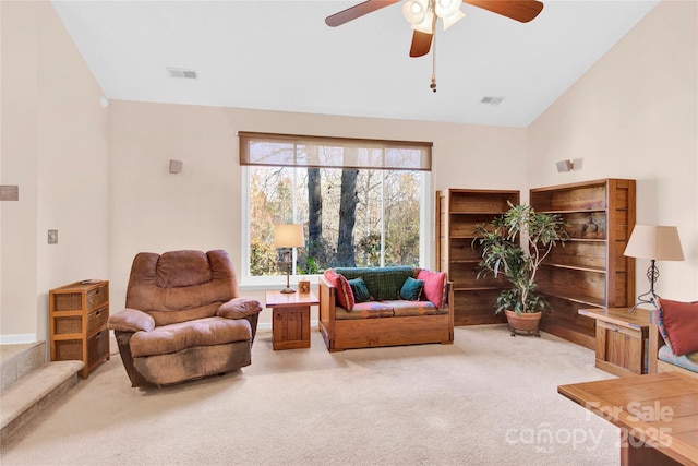 carpeted living room with a ceiling fan, lofted ceiling, and visible vents