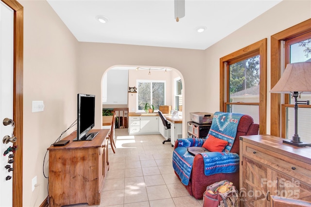 living area with light tile patterned floors and arched walkways