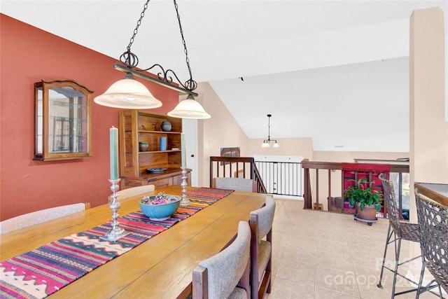 dining space with vaulted ceiling and tile patterned floors