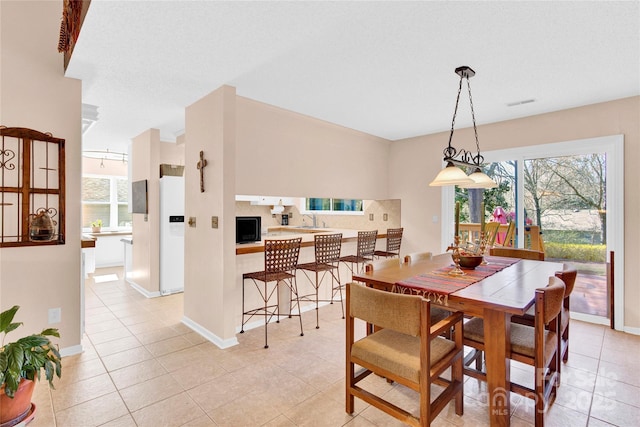 dining space featuring a healthy amount of sunlight, baseboards, and light tile patterned floors