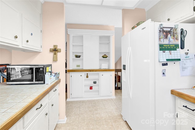 kitchen featuring white cabinets, white fridge with ice dispenser, stainless steel microwave, and open shelves