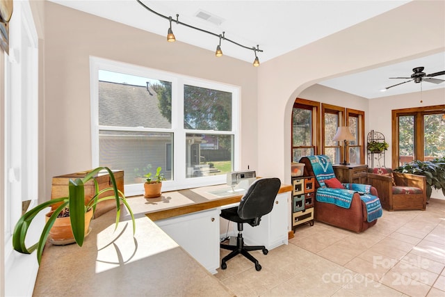 office featuring arched walkways, visible vents, rail lighting, and light tile patterned floors