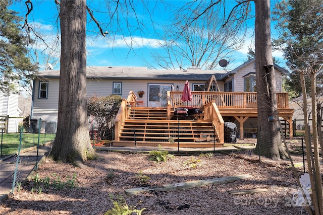 view of front of property featuring stairway, fence, and a wooden deck