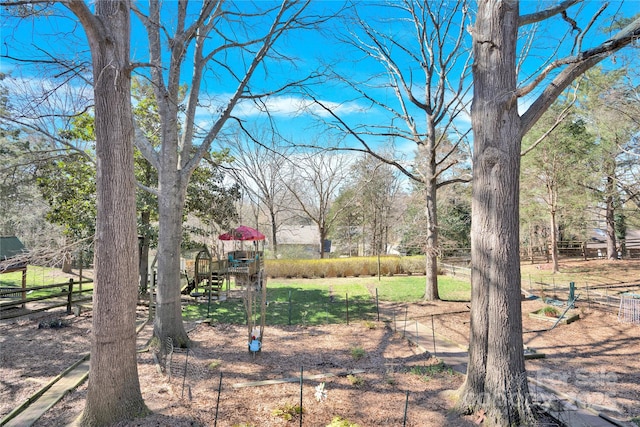 view of yard with playground community and fence