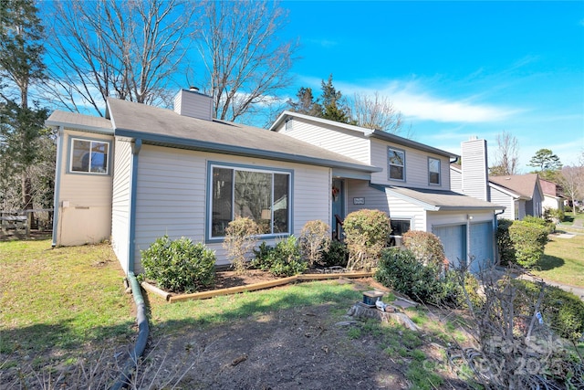 tri-level home featuring a chimney and a front lawn