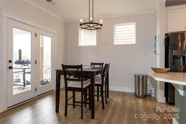 dining space featuring a notable chandelier, visible vents, ornamental molding, dark wood-type flooring, and baseboards