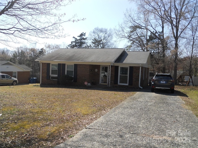 ranch-style home featuring brick siding and driveway