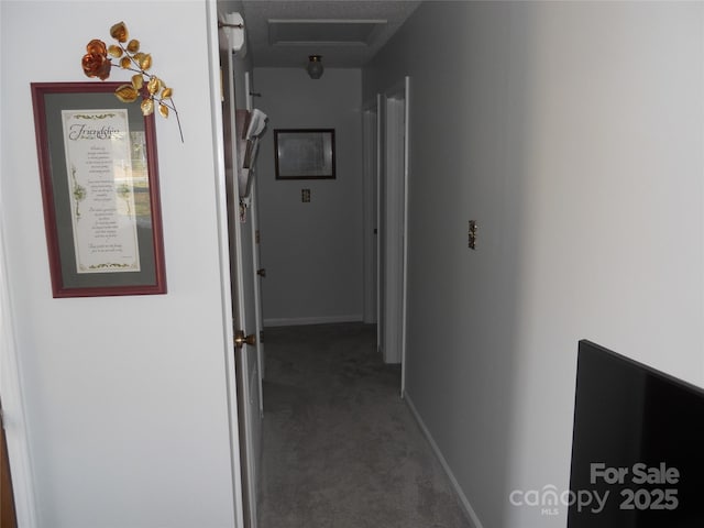 corridor featuring attic access, baseboards, and carpet floors