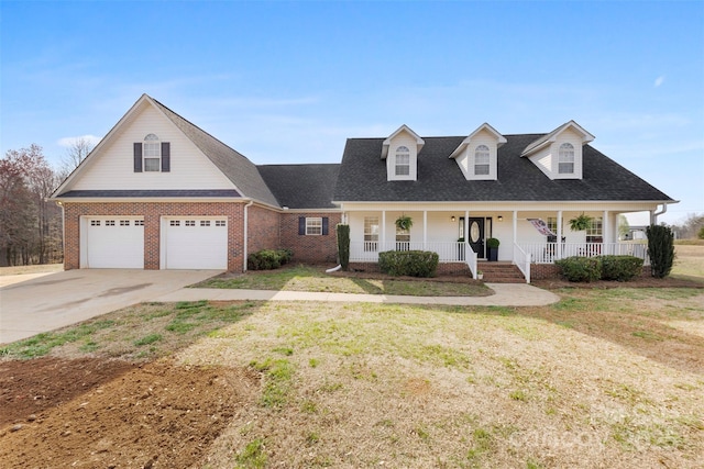 view of front of house featuring a front yard, covered porch, concrete driveway, a garage, and brick siding