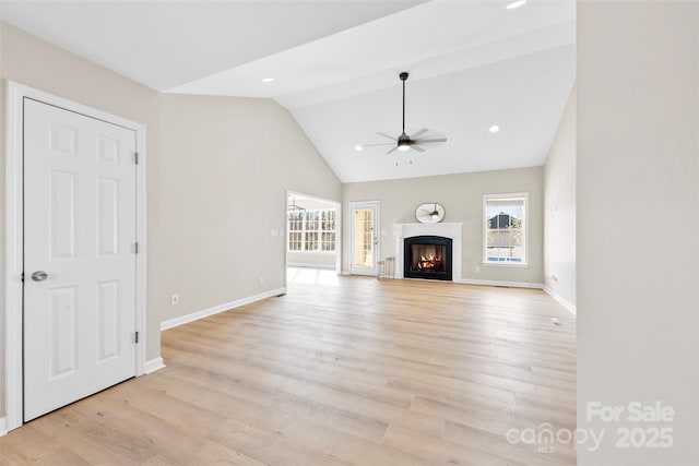 unfurnished living room with light wood-style floors, a healthy amount of sunlight, and a ceiling fan