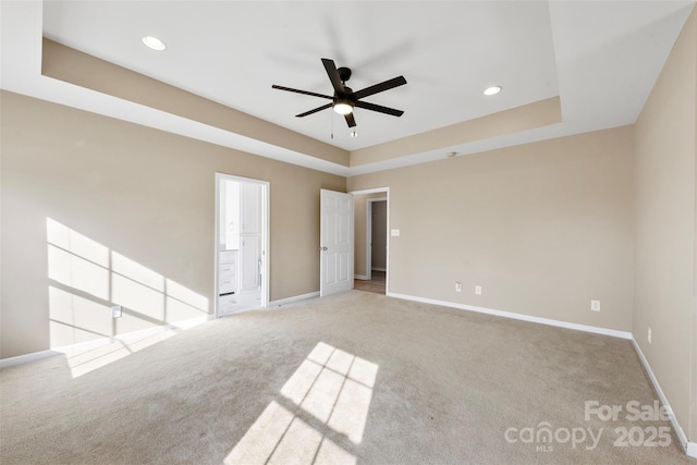 unfurnished room with a tray ceiling, recessed lighting, carpet, baseboards, and ceiling fan