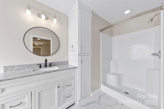 full bathroom featuring marble finish floor, vanity, and a shower