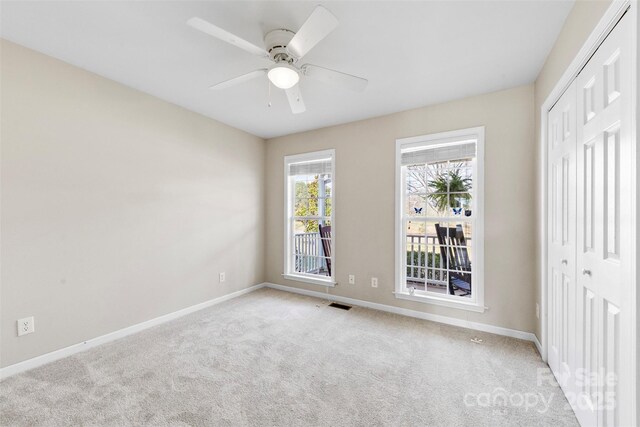 interior space with visible vents, baseboards, and a ceiling fan