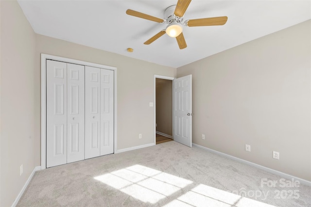 unfurnished bedroom featuring a closet, baseboards, carpet, and ceiling fan