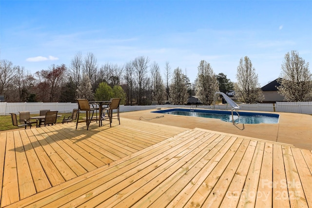 view of swimming pool with a fenced in pool, a deck, a water slide, and a fenced backyard