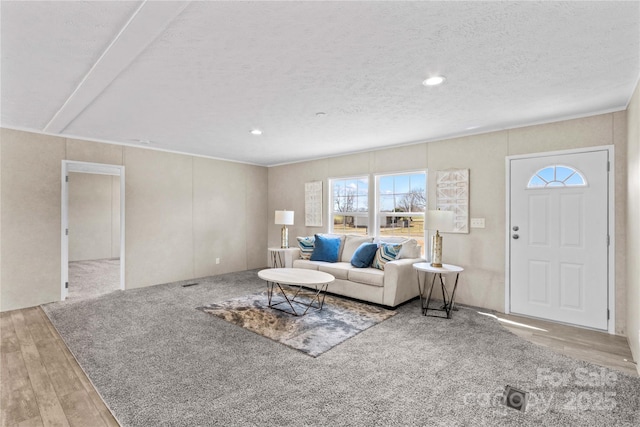 living area featuring recessed lighting, a textured ceiling, and wood finished floors