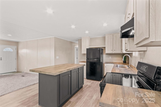 kitchen with under cabinet range hood, a sink, light wood-type flooring, a center island, and black appliances