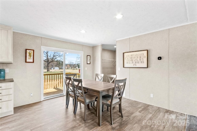 dining room with a textured ceiling and light wood finished floors