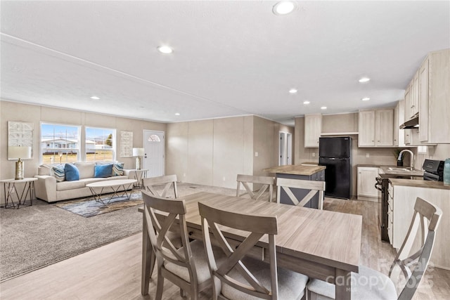 dining room with light wood-style flooring and recessed lighting