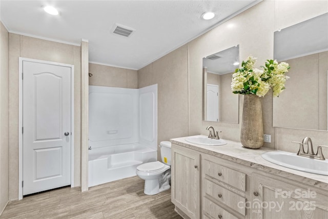 full bathroom featuring toilet, wood finished floors, a sink, and visible vents