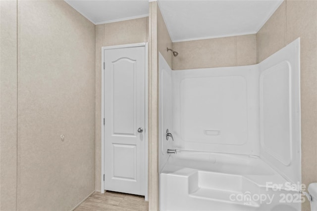 full bath featuring shower / bathtub combination, wood finished floors, and crown molding