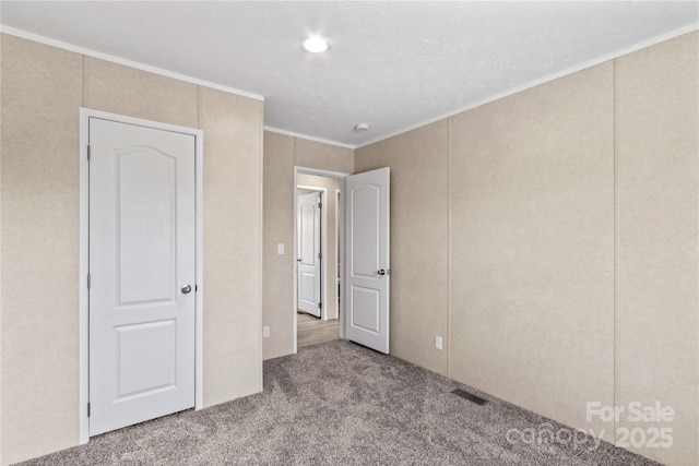 unfurnished bedroom with carpet, visible vents, and crown molding