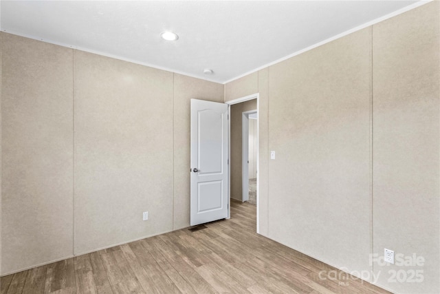 spare room featuring wood finished floors and crown molding