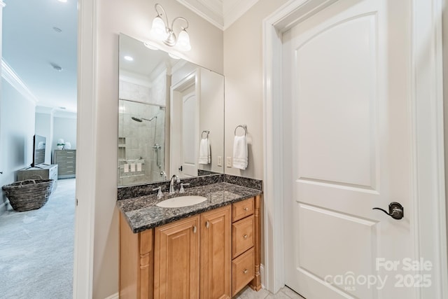 bathroom with tiled shower, vanity, and crown molding