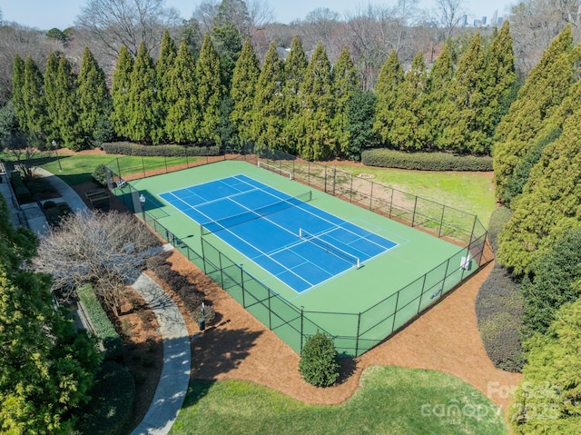 view of sport court with fence and a lawn