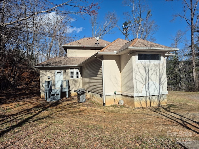 rear view of property with roof with shingles