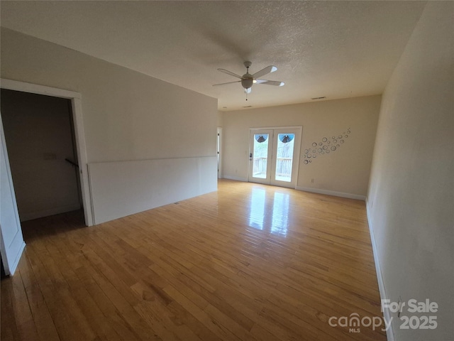 spare room with baseboards, ceiling fan, a textured ceiling, and hardwood / wood-style floors