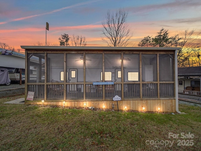 rear view of house featuring a yard and a sunroom