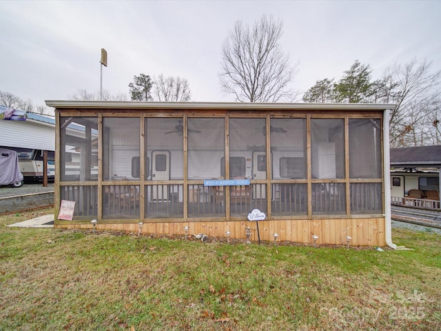 back of house with a sunroom and a yard