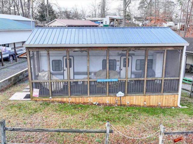 exterior space with metal roof and a sunroom