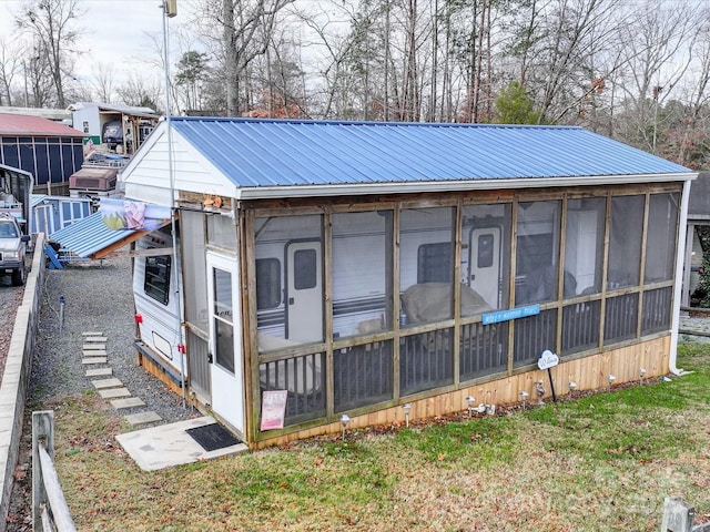 exterior space with metal roof and a sunroom