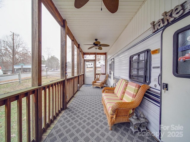 sunroom / solarium featuring a ceiling fan