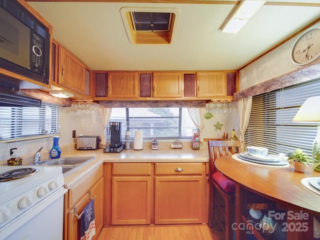 kitchen featuring light wood-style floors, built in microwave, white electric range, and light countertops