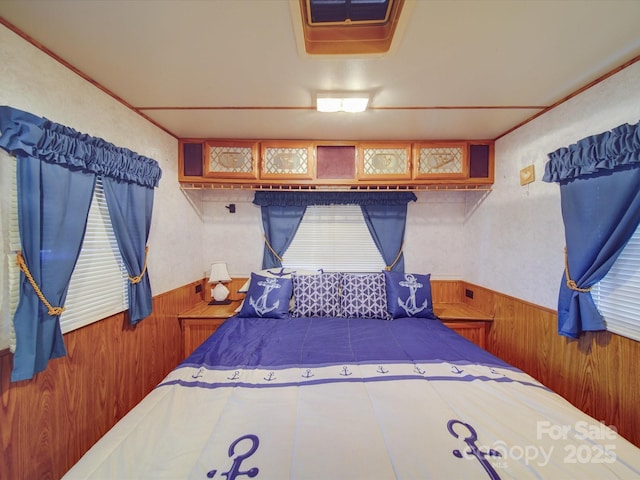 bedroom with wooden walls and wainscoting